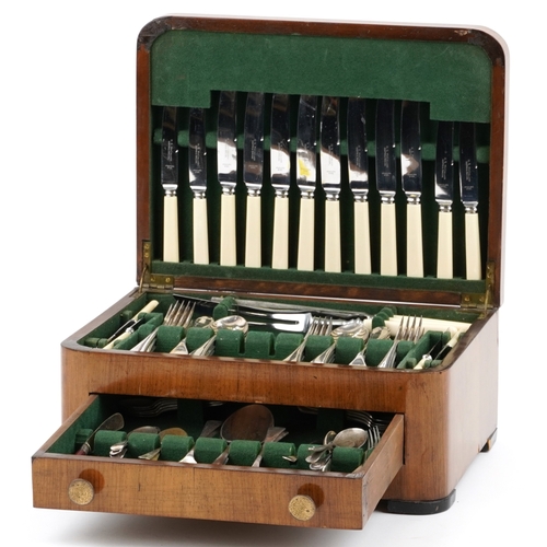 3749 - An Art Deco walnut cased canteen of stainless steel cutlery, 36cm wide.