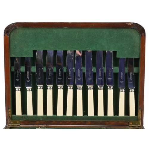 3749 - An Art Deco walnut cased canteen of stainless steel cutlery, 36cm wide.