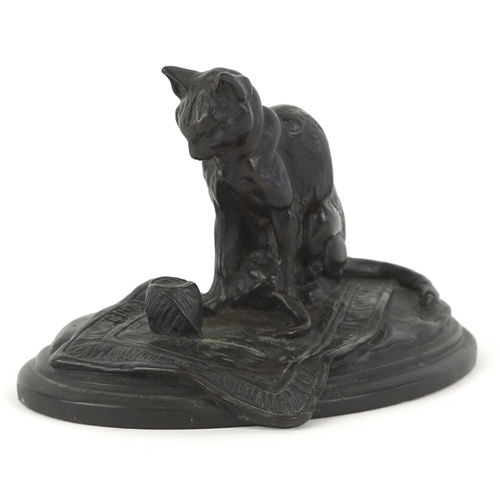 1451 - After E. Fremiet, a bronzed sculpture of a cat on a rug on an oval plinth base, 9cm high.