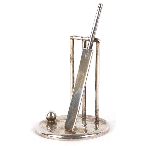 3640 - Edward Victor Stanley, a silver cricket bat and stumps on a planished base, London 1995, 7cm high, 3... 