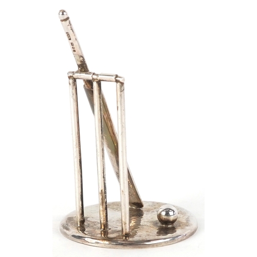 3640 - Edward Victor Stanley, a silver cricket bat and stumps on a planished base, London 1995, 7cm high, 3... 