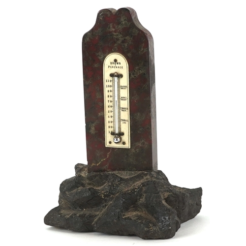 313 - A brown Penzance Cornish serpentine marble thermometer raised on a naturalistic granite base, 18cm h... 