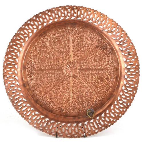 1893 - A Middle Eastern copper tray with repousse floral decoration and pierced rim, 38cm in diameter.