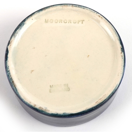 191 - A Moorcroft pottery pot and cover hand painted in the Hibiscus pattern, 7cm in diameter.