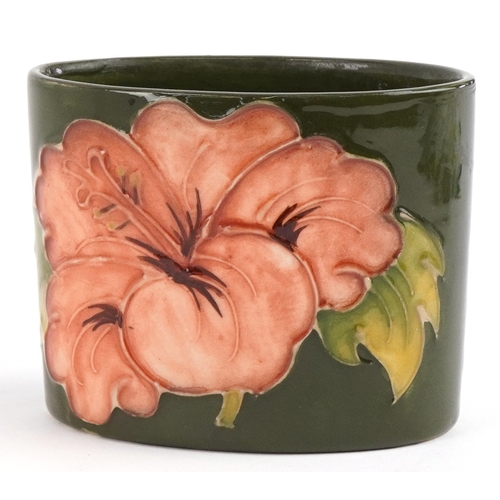 185 - A Moorcroft pottery pot hand painted in the Hibiscus pattern, 6cm high x 7.5cm wide.
