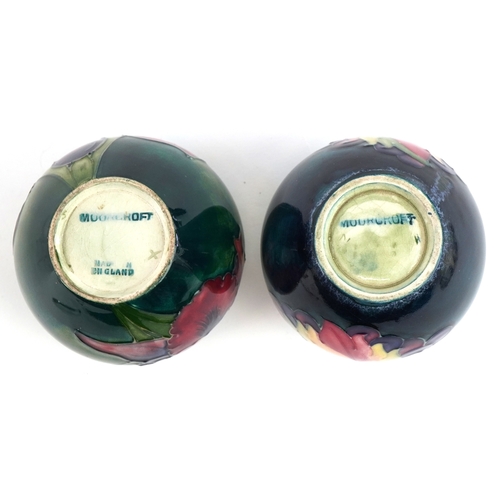 182 - Two Moorcroft pottery squat vases hand painted in the Leaf & Berry and Orchid patterns, 7.5cm high.