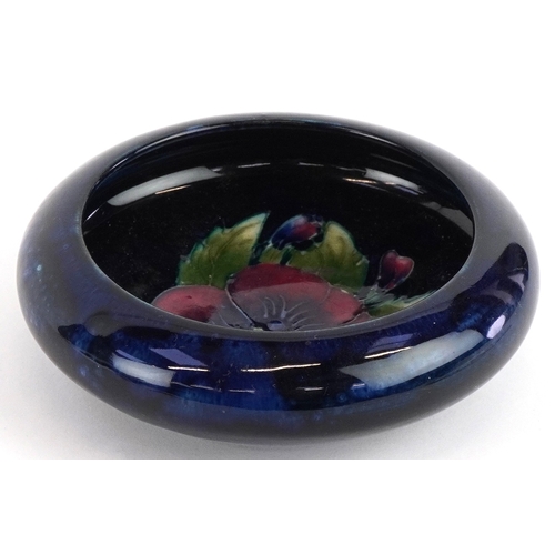 186 - A Moorcroft pottery dish hand painted in the Pansy pattern, 11cm in diameter.