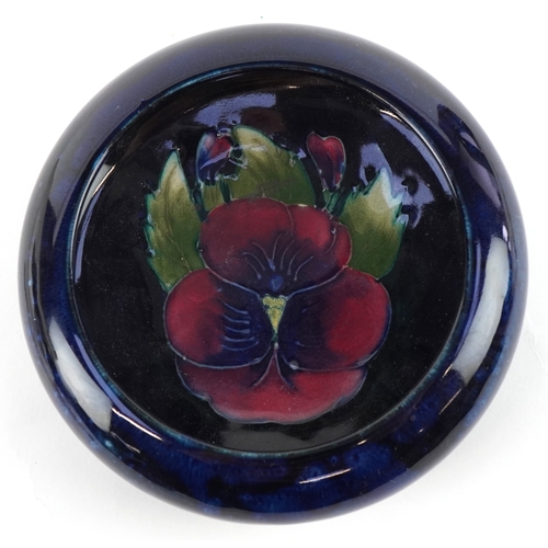 186 - A Moorcroft pottery dish hand painted in the Pansy pattern, 11cm in diameter.