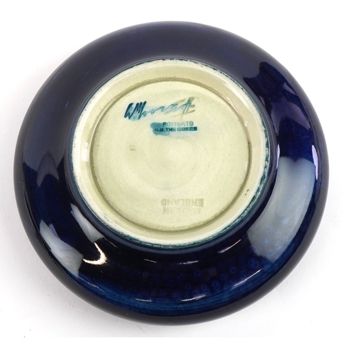186 - A Moorcroft pottery dish hand painted in the Pansy pattern, 11cm in diameter.
