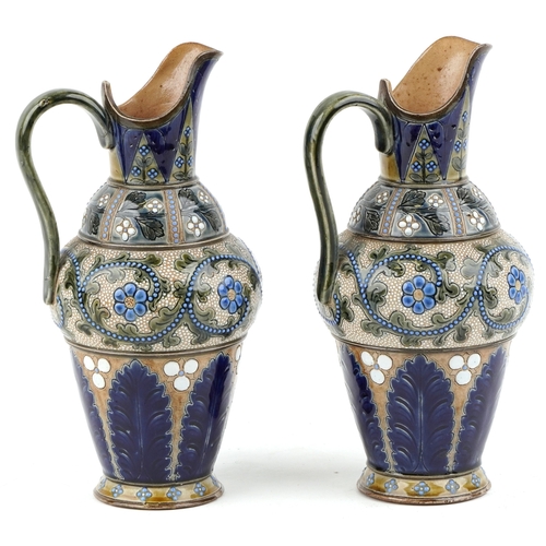 324 - A pair of Art Nouveau James Stiff Lambeth stoneware ewers hand painted with stylized flowers, 26cm h... 