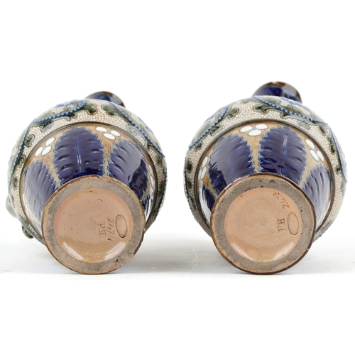 324 - A pair of Art Nouveau James Stiff Lambeth stoneware ewers hand painted with stylized flowers, 26cm h... 