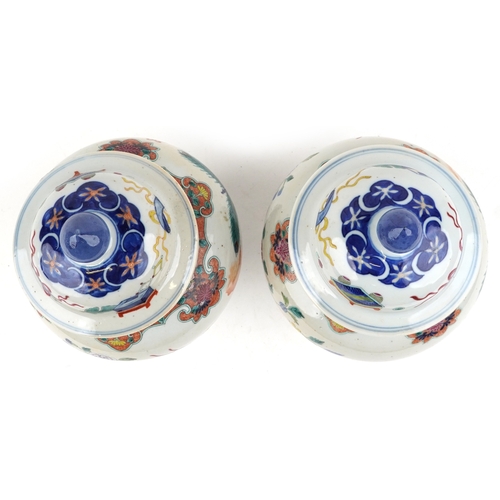 88 - A near pair Chinese porcelain baluster vases and covers, each hand painted with objects amongst a fl... 