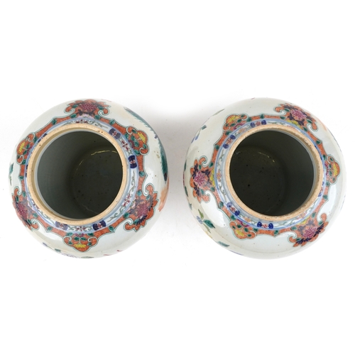88 - A near pair Chinese porcelain baluster vases and covers, each hand painted with objects amongst a fl... 