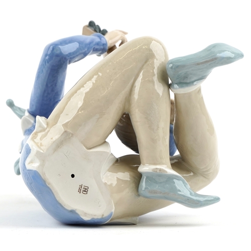 623 - A large Nao porcelain figure of a jester playing a lute, 34cm high.