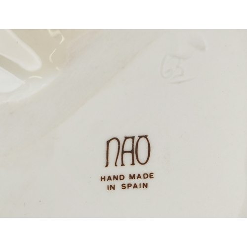 623 - A large Nao porcelain figure of a jester playing a lute, 34cm high.