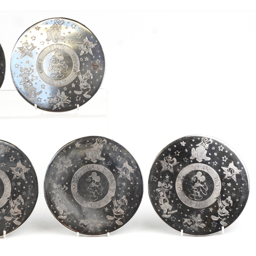 1639 - A set of eight Walt Disney Productions silver plated coasters engraved with Disney figures, 19cm in ... 