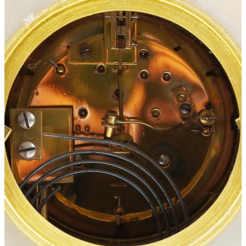 125 - An onyx and brass three piece clock garniture, the clock having an enamelled dial with Arabic numera... 