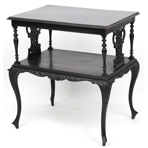 2072 - An early 20th century ebonised two tier side table with carved decoration, raised on cabriole legs, ... 