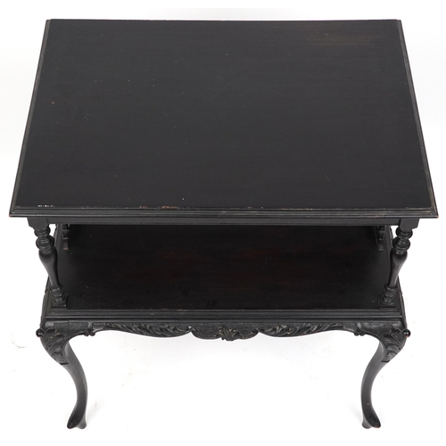 2072 - An early 20th century ebonised two tier side table with carved decoration, raised on cabriole legs, ... 