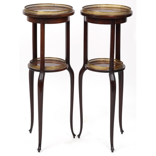 2068 - A pair of early 20th century mahogany jardinière stands, each with brass galleries, raised on tripod... 