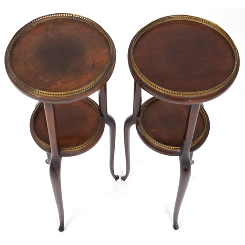 2068 - A pair of early 20th century mahogany jardinière stands, each with brass galleries, raised on tripod... 