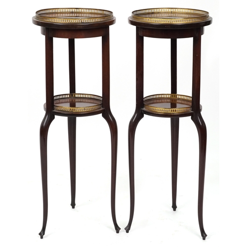 2068 - A pair of early 20th century mahogany jardinière stands, each with brass galleries, raised on tripod... 