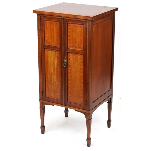 2042 - An Edwardian mahogany music cabinet with satinwood crossbanded decoration, raised on square tapering... 