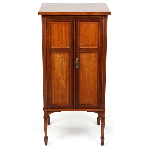 2042 - An Edwardian mahogany music cabinet with satinwood crossbanded decoration, raised on square tapering... 