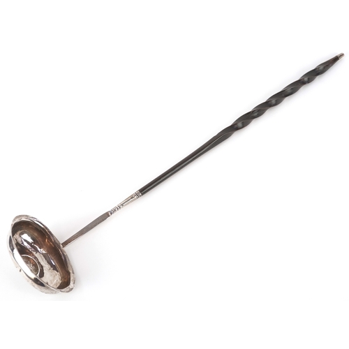 3642 - A George III silver ladle with twisted horn handle, the bowl set with a 1787 shilling, indistinct ha... 