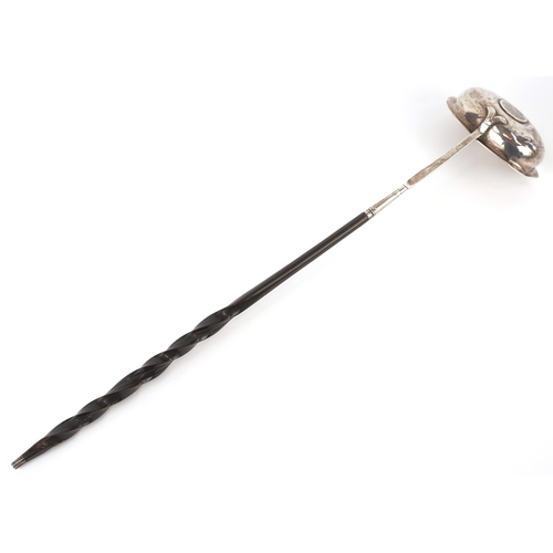 3642 - A George III silver ladle with twisted horn handle, the bowl set with a 1787 shilling, indistinct ha... 