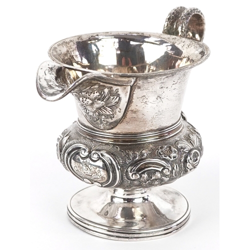 3584 - A George IV silver cream jug having a floral embossed body, entwined serpent handle and a later adde... 