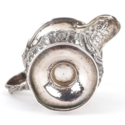 3584 - A George IV silver cream jug having a floral embossed body, entwined serpent handle and a later adde... 