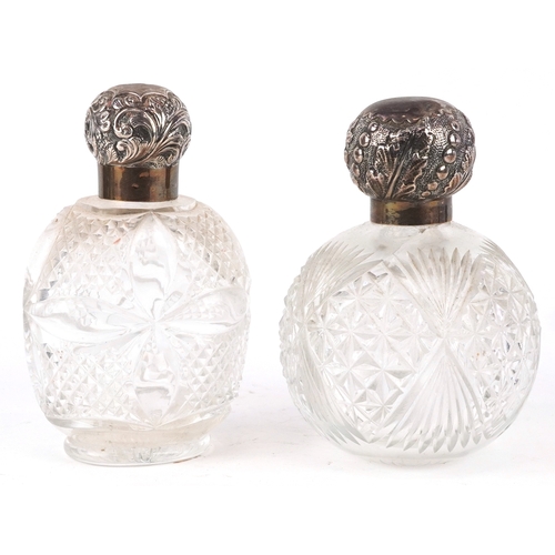 3610 - Two Victorian cut glass scent bottles with embossed silver lids, the largest 14cm high.