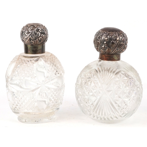 3610 - Two Victorian cut glass scent bottles with embossed silver lids, the largest 14cm high.