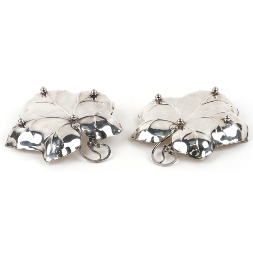 1652 - A pair of 20th century silver plated leaf dishes on ball feet, 25cm wide.
