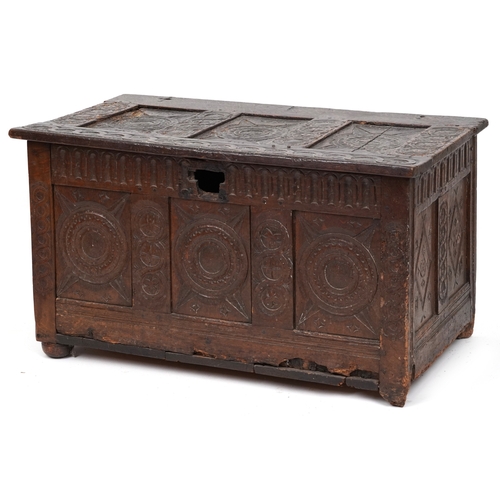 2016 - A 17th century oak triple panel coffer with carved decoration, the hinged lid above a linenfold frie... 