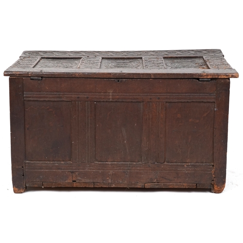 2016 - A 17th century oak triple panel coffer with carved decoration, the hinged lid above a linenfold frie... 