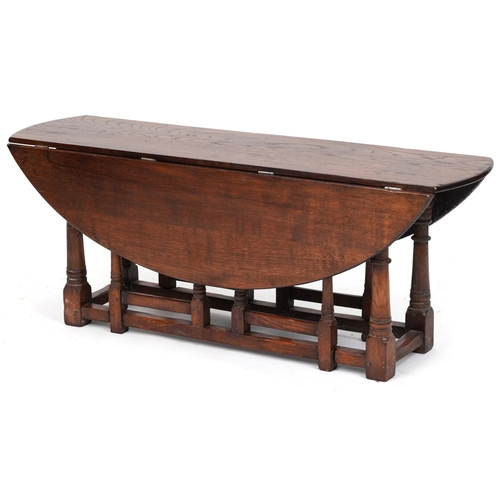 2080 - A 20th century oak drop flap coffee table raised on turned and block supports, 48cm H x 123cm W x 90... 