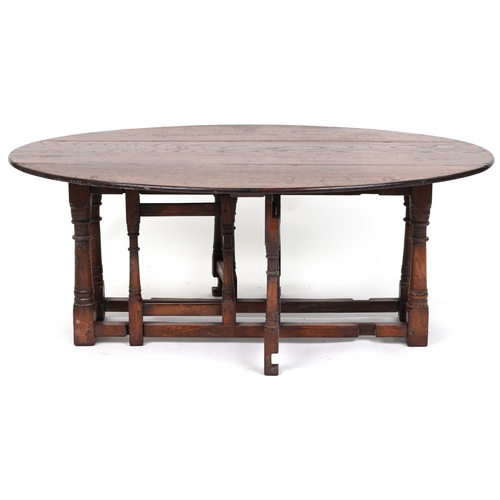 2080 - A 20th century oak drop flap coffee table raised on turned and block supports, 48cm H x 123cm W x 90... 