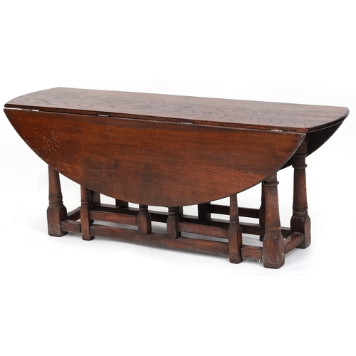 2080 - A 20th century oak drop flap coffee table raised on turned and block supports, 48cm H x 123cm W x 90... 
