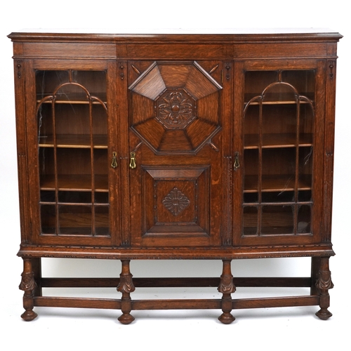 2079 - A late Victorian oak display cabinet, the carved central panel door flanked by two glazed cabinets, ... 