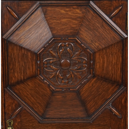 2079 - A late Victorian oak display cabinet, the carved central panel door flanked by two glazed cabinets, ... 