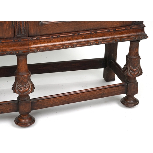 2079 - A late Victorian oak display cabinet, the carved central panel door flanked by two glazed cabinets, ... 