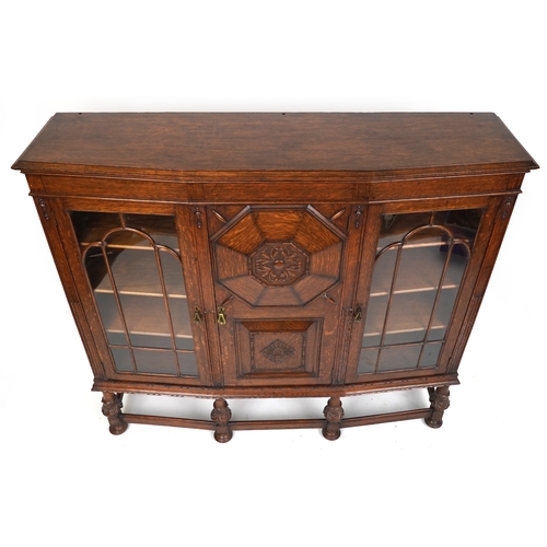 2079 - A late Victorian oak display cabinet, the carved central panel door flanked by two glazed cabinets, ... 