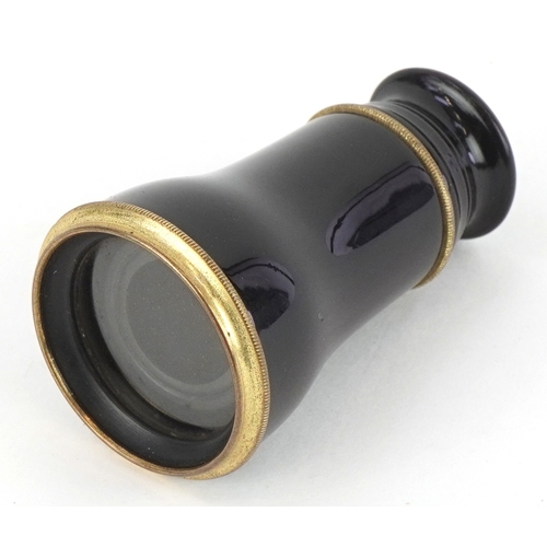 299 - An early 20th century brass and black enamel monocular, 5.5cm in length folded.