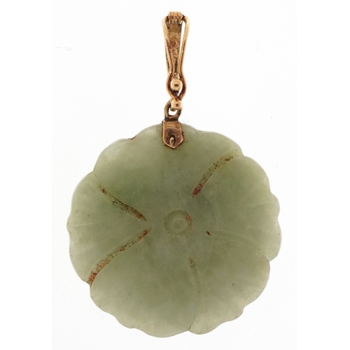 3290 - A Chinese unmarked gold green stone pendant carved in the form of a flower, 2.5cm in diameter, 7.7g.