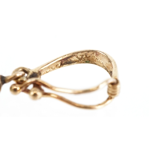 3290 - A Chinese unmarked gold green stone pendant carved in the form of a flower, 2.5cm in diameter, 7.7g.