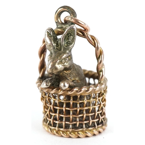 3171 - A 9ct gold charm in the form of a basket with a silver rabbit, 1.7cm high, 4.0g.