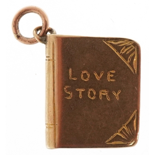 3118 - A 9ct gold charm in the form of a book inscribed 'Love Story', 1.3cm high, 1.4g.