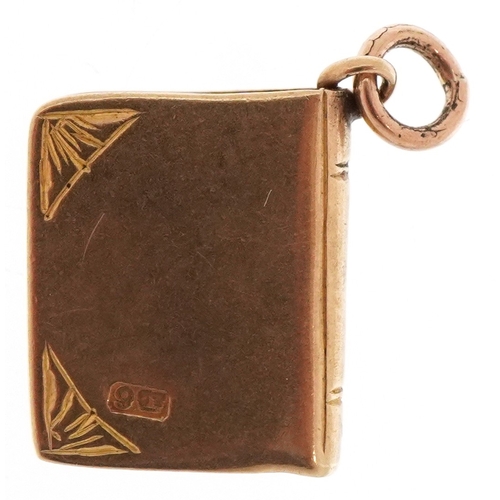 3118 - A 9ct gold charm in the form of a book inscribed 'Love Story', 1.3cm high, 1.4g.